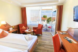Cette chambre d'hôtel comprend un lit et un balcon. dans l'établissement Kurhotel Sonnenhof, à Bad Füssing
