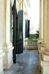 una puerta abierta de un edificio con persianas negras en Villa maria, en Galatina