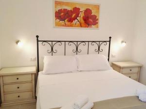 アレーツィオにあるAgriturismo Capaniのベッドルーム1室(白いベッド1台、ナイトスタンド2台付)