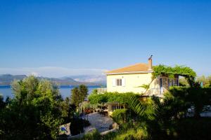 a house on the shore of a body of water at Pantheon Studios in Nikiana