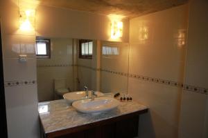a bathroom with two sinks and a mirror at Thamaya Heritance Tangalle in Tangalle