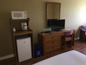 a hotel room with a desk with a computer and a microwave at Annapolis Royal Inn in Annapolis Royal