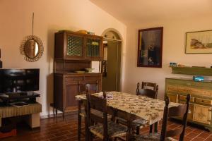 a dining room with a table and a tv at Country House Carmelita in Limigiano