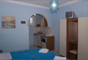 eine Küche mit einem blauen Bett in einem Zimmer in der Unterkunft Paraskevi Apartments in Paleokastritsa