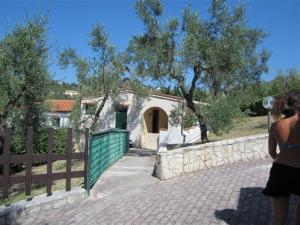 Villaggio Mare Blu في فييستي: امرأة تقف بجوار سور ومنزل