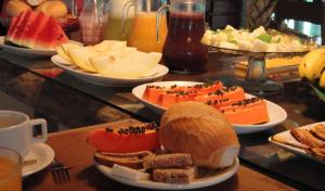 a buffet with plates of food on a table at Pousada Praia de Itamambuca in Ubatuba