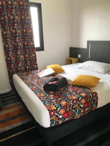 a bed with a blanket on it with a book on it at Kyriad Direct La Rochelle Aytré in Aytré