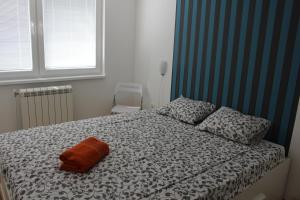 een slaapkamer met een bed met een oranje kussen erop bij Skopje home 2 in Skopje