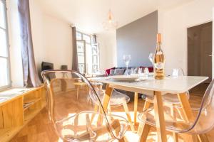 uma sala de estar com uma mesa com cadeiras e uma garrafa de vinho em charming city center flat em Rouen