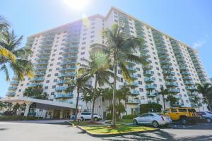 un gran edificio con palmeras en un aparcamiento en Ocean Reserve Luxury Condos Across from Sunny Isles Beach en Miami Beach