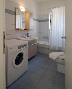 a bathroom with a washing machine and a sink at Astarte Sea Villas in Dhiakofti