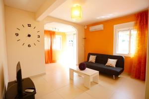 a living room with a couch and a clock on the wall at Villa hortencia in Tarragona