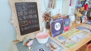 una scrivania con una lavagna e dei libri sopra di Princess Chloe B&B a Città Vecchia di Hengchun