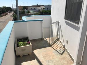 a balcony with a flower pot on the side of a building at Casa Gada in Torre Lapillo