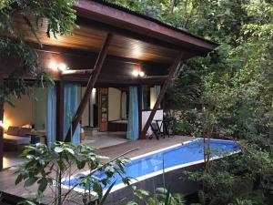 a house in the forest with a swimming pool at Residencial Warabi in Visconde De Maua