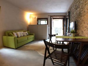 een woonkamer met een groene bank en een tafel bij Studio Ca d'Martin in Vicosoprano