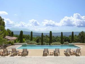 a group of chairs and a swimming pool at Hôtel - le Jas de Joucas in Joucas
