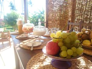 a table with a bowl of fruit on it at Hara Pousada e SPA in São Miguel do Gostoso