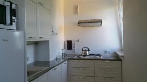 a kitchen with white cabinets and a tea kettle at Zamość przy Starówce in Zamość