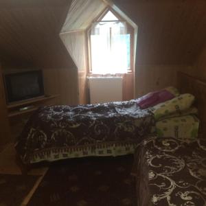 a small bedroom with two beds and a window at Krasa Karpat in Snidavka