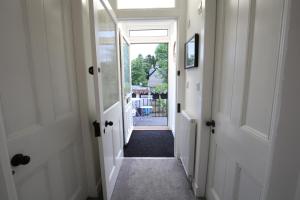 un pasillo con una puerta que conduce a un patio en High Terrace Apartment en Boat of Garten