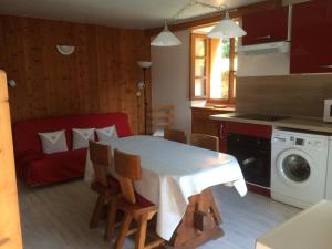 uma cozinha com uma mesa e um sofá vermelho em Appartement Claude em Courchevel