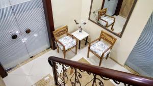 Habitación con 2 sillas y mesa con espejo. en Hotel Orleans, en Petrópolis