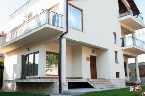 a white house with a staircase and a door at Complex Adal in Eforie Nord
