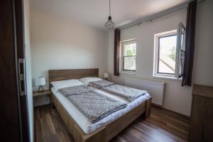 Un dormitorio con una cama grande y una ventana en Boka Apartmanház, en Gyula