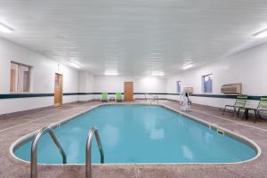 ein großer Pool in einem großen Zimmer mit Stühlen in der Unterkunft Super 8 by Wyndham Bedford in Bedford
