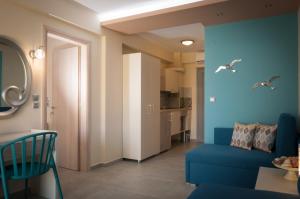 a living room with a blue couch and a kitchen at KalyBay in Kalives Poligirou
