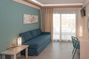 a living room with a blue couch and a table at KalyBay in Kalives Poligirou