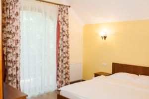 a bedroom with a bed and a large window at Complex Adal in Eforie Nord +81 photos