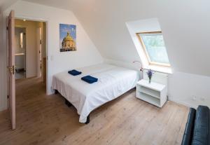 a bedroom with a white bed and a window at Pedersminde Guesthouse in Fredensborg