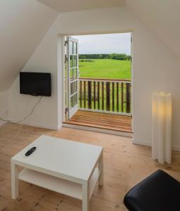 a living room with a white coffee table and a large window at Pedersminde Guesthouse in Fredensborg