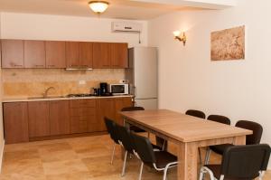 a kitchen and dining room with a wooden table and chairs at Complex Adal in Eforie Nord