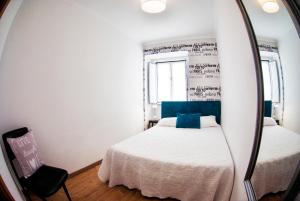a bedroom with a mirror and a bed and a chair at Belém Apartment in Lisbon