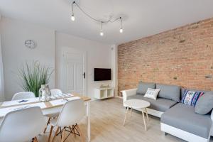 a living room with a couch and a brick wall at Lion Apartments - La Playa in Sopot