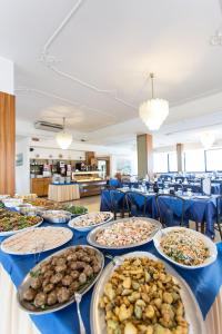 une longue table avec des assiettes de nourriture dans l'établissement Hotel Miramare, à Gatteo a Mare