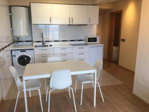 - une cuisine avec une table et des chaises blanches dans l'établissement Apartamento frente al mar, à San Pedro 15 autres photos