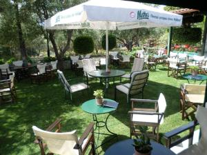 a group of tables and chairs in the grass at Mary's Apartments in Chrani +11 photos