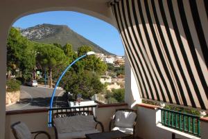 a room with a balcony with a view of a mountain at Acacia Appartamenti in Cala Gonone