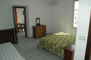 1 dormitorio con cama, tocador y espejo en Acacia Appartamenti, en Cala Gonone