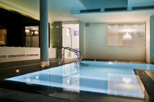 a swimming pool in a building with a chandelier at Kadrit Hotel in Cadrete