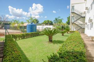 a yard with plants and a water tower and a building at Hotel Vila Verde in Rondonópolis