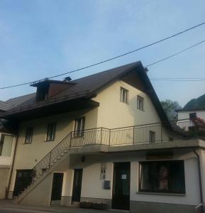 un edificio con balcone e una donna alla finestra di Apartma Center a Bovec