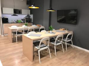 una sala da pranzo con tavoli, sedie e TV di Sleep in Hostel & Apartments Stare Miasto a Poznań