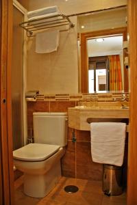 y baño con aseo, lavabo y espejo. en Hostal Victoria I, en Madrid