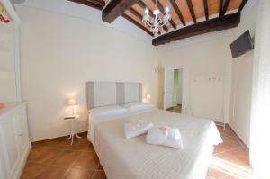 Un dormitorio con una cama blanca con dos toallas blancas. en La Nicchia - Serena Tuscany Homes, en Cortona