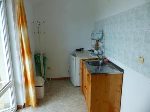 a small kitchen with a sink and a washing machine at Sunhouse Rooms in Tsarevo